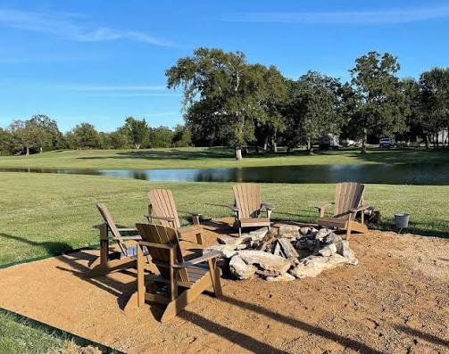 Fire pit and Adirondack chairs by the pond